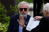 Former Sinn Fein President Gerry Adams sits outside the High Court, in Dublin