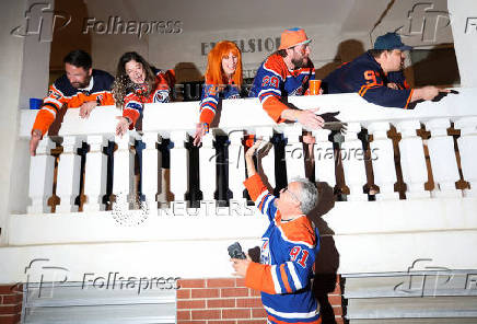 Edmonton Oilers fans react in a fan zone during the first game of the Stanley Cup Finals against the Florida Panthers, in Edmonton