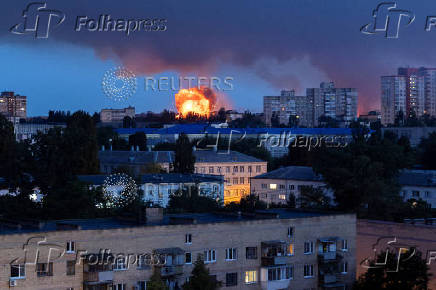 A plume of fire and smoke rises into the sky near residential buildings after a Russian missile strike in Kyiv