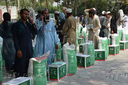 Afghan families, returned from neighboring Pakistan, receive food rations distributed by the Tawheed Charity Foundation in Jalalabad