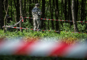 Polish expert works at the burial site of Poles killed by Ukrainian nationalists during World War II before the upcoming exhumation in the former village of Puzhnyky