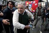 FILE PHOTO: Uruguayan President Jose Mujica arrives for the celebration of the Worker's Day carrying his pet dog Manuela