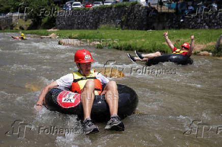 Sports enthusiasts compete while floating on inner tyre tubes during the tyre festival 'Bunar Fest' in Prizren