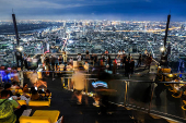 Tourists enjoy a view at the Mahanakhon Skywalk rooftop in Bangkok