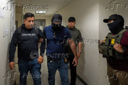 A migrant is detained by federal immigration officers at U.S. immigration court in Manhattan
