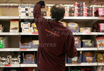 FILE PHOTO: A member of staff works at a Sainsbury's supermarket in London