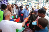Volunteers distribute cold drinks on a roadside in Hyderabad