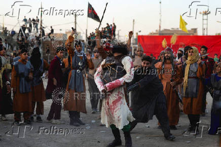 Volunteers re-enact a scene from the 7th-century Battle of Karbala to commemorate Ashura in Baghdad