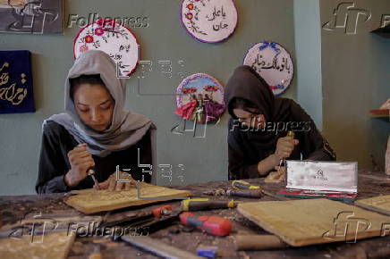 Afghan girl teach Nuristani wood carving skills at a workshop in Kabul