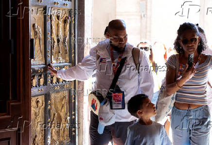 Young pilgrims pass through the Holy Door of St. Peter's Basilica during Jubilee of Youth, at the Vatican