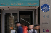 People walk past the John Harvard blue plaque outside the John Harvard Library on Borough High Street, London