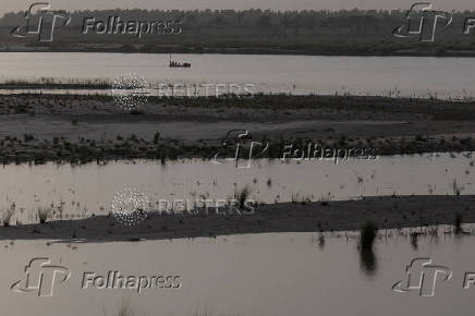 Fishermen search spot to set nets along Chenab River in Multan, Pakistan