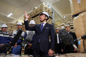Japan's Agriculture, Forestry and Fisheries Minister Shinjiro Koizumi speaks to the media as he inspects a warehouse storing stockpiled rice in Kanagawa