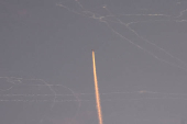 A military aircraft flies in the sky following a barrage of missiles launched from Iran, as seen over Tubas