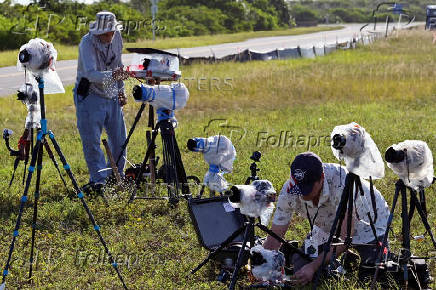 Photographers set up remote cameras as a Falcon 9 rocket stands at Launch Complex 39-A while the Axiom-4 crewed mission prepares for its launch to the International Space Station