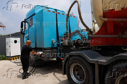 Truck driver charges a Sany electric heavy truck at a charging station in Langfang
