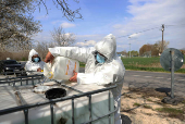 A member of the epidemic authorities fills a container with disinfectant liquid during the outbreak of foot-and-mouth disease in Dunakiliti