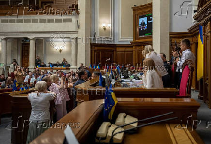 Lawmaker Oleksii Honcharenko holds smartphones as he live streams a session of Ukrainian parliament in Kyiv