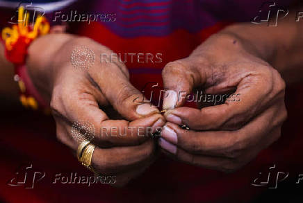 A goldsmith works on a gold chain inside a jewellery making workshop in Mumbai