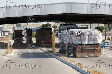 Trucks carrying aid line up at the Kerem Shalom crossing between Israel and Gaza, before going into Gaza, on the Israeli side of the Israel-Gaza border