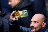 Man holds phone with Argentina's former President Kirchner outside Partido Justicialista headquarters in Buenos Aires