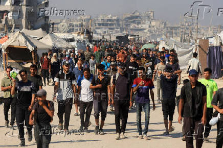Palestinians gather as they wait for aid supplies to enter Gaza