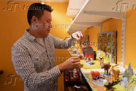 CEO Jason Cheung of toy manufacturer Huntar Company Inc adjusts some of the toys on display at his U.S. office in Union City
