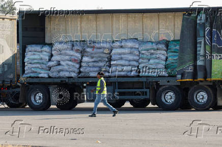 A worker walks near a truck carrying aid at the Kerem Shalom crossing between Israel and Gaza, before going into Gaza, on the Israeli side of the Israel-Gaza border