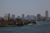 A general view of a farmland with houses on small island next to crowded residential buildings and bridges on the bank of River Nile, in Cairo