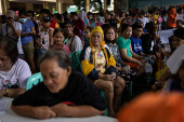 Residents affected by monsoon rains queue for relief following monsoon rains in Quezon City