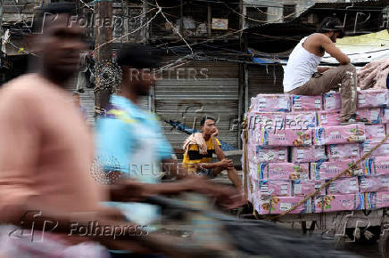 Labourers rest on handcarts in a wholesale market
