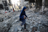 Palestinians inspect the damage at the site of an Israeli strike on a house, in Jabalia