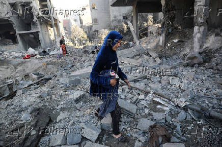 Palestinians inspect the damage at the site of an Israeli strike on a house, in Jabalia