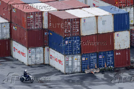 A person rides a scooter near containers in Keelung