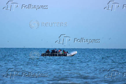 A group of migrants sit on a dinghy whilst trying to cross the English Channel near Gravelines