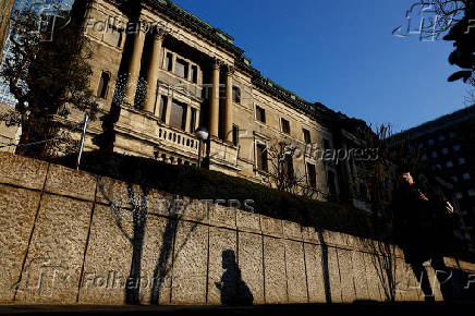 FILE PHOTO: A passerby walks past in front of the Bank of Japan headquarters in Tokyo