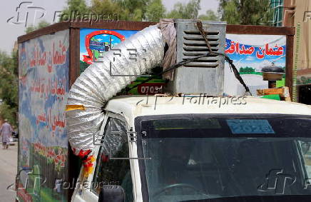 Taxi drivers install locally made air coolers to beat the heat in Kandahar