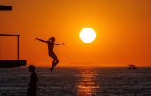 A woman jumps into the Adriatic sea during warm weather in Zadar