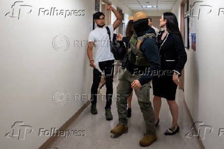 A migrant is detained by federal immigration officers at U.S. immigration court