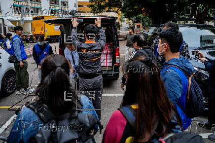 Hong Kong residents affected by the fire gather their belongings from their apartments