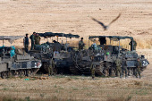 Israeli soldiers stand next to military vehicles, near the border with Gaza
