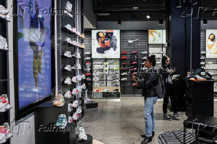FILE PHOTO: A customer looks at shoes at a Footlocker store in New York City