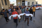Mourners carry the bodies of Palestinians killed in an Israeli strike, in Gaza City