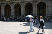 A woman near the Louvre museum on a warm and sunny day in Paris