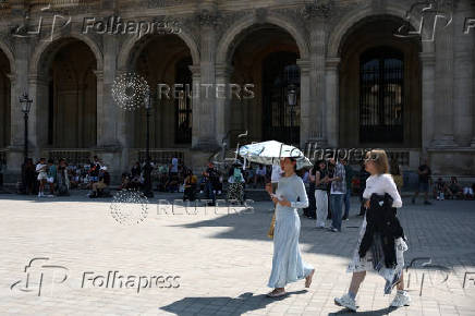 A woman near the Louvre museum on a warm and sunny day in Paris