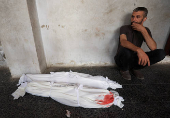 Mourners react near the bodies of Palestinians killed in an Israeli strike, in Gaza City