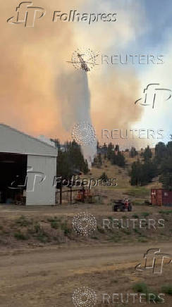 Helicopter dumps water over raging fire in Oregon's Jefferson County