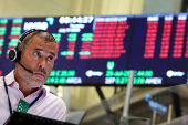 Traders work on the floor of the AMEX at the NYSE in New York