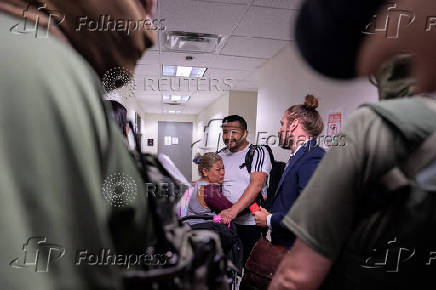 A migrant is embraced by his wife when he is informed that he is going to be detained by federal immigration officers at U.S. immigration court in Manhattan
