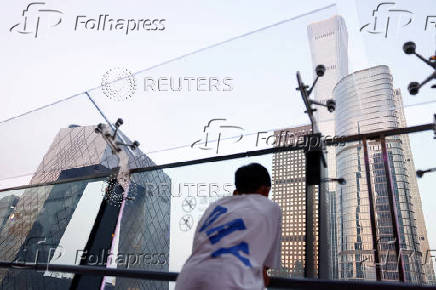 A person looks on at a terrace of a shopping mall in Beijing's CBD